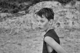 A boy stands near the dunes