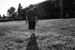 Boy walking with strong sunlight.