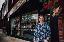 Ann Shea, owner of Mill Street Books poses in front of her bookstore.